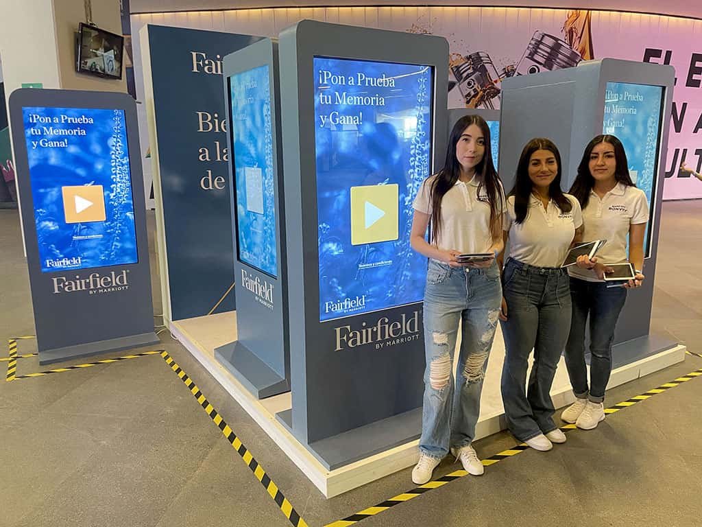edecanes en stand publicitario en una expo